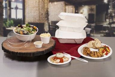 A family enjoying a meal at home with compostable plates, bowls, and cups